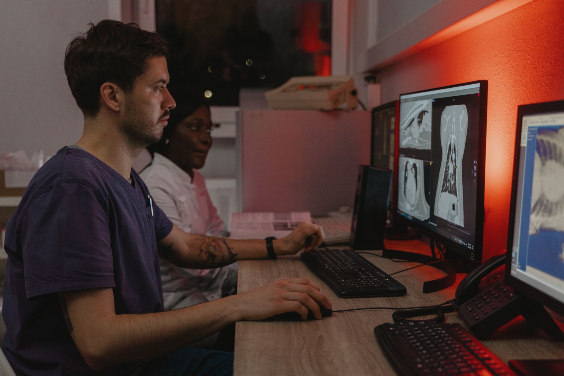 A clinical team reading a shared screen together in a hospital corridor